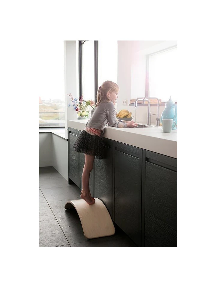 Mała dziewczynka na desce balansującej w kuchni.
