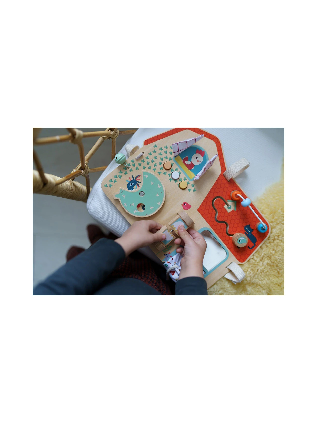 Rączki dziecka otwierające drzwiczki na drewnianej tablicy manipulacyjnej Farma od Lilliputiens