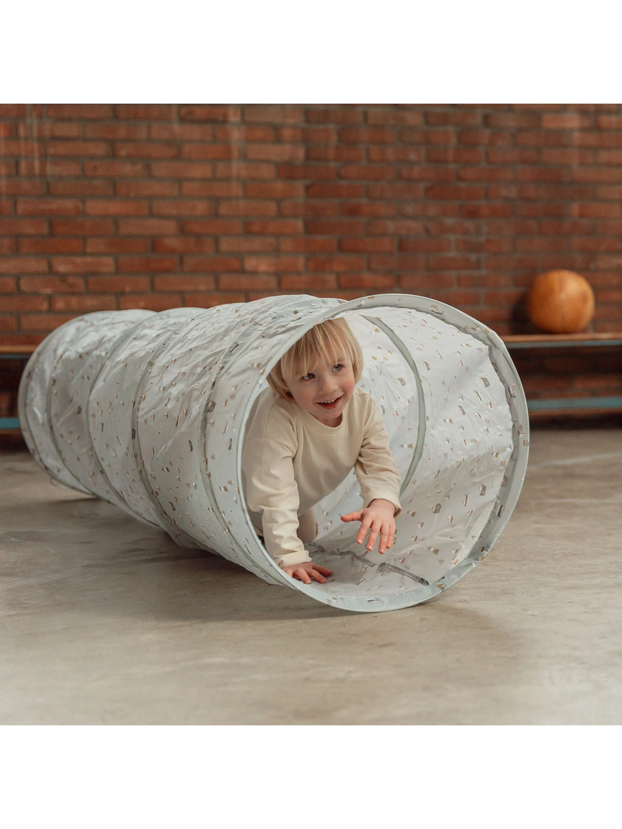 Małe dziecko bawiące się w tunelu dziecięcym z serii Sailors Bay od Little Dutch.
