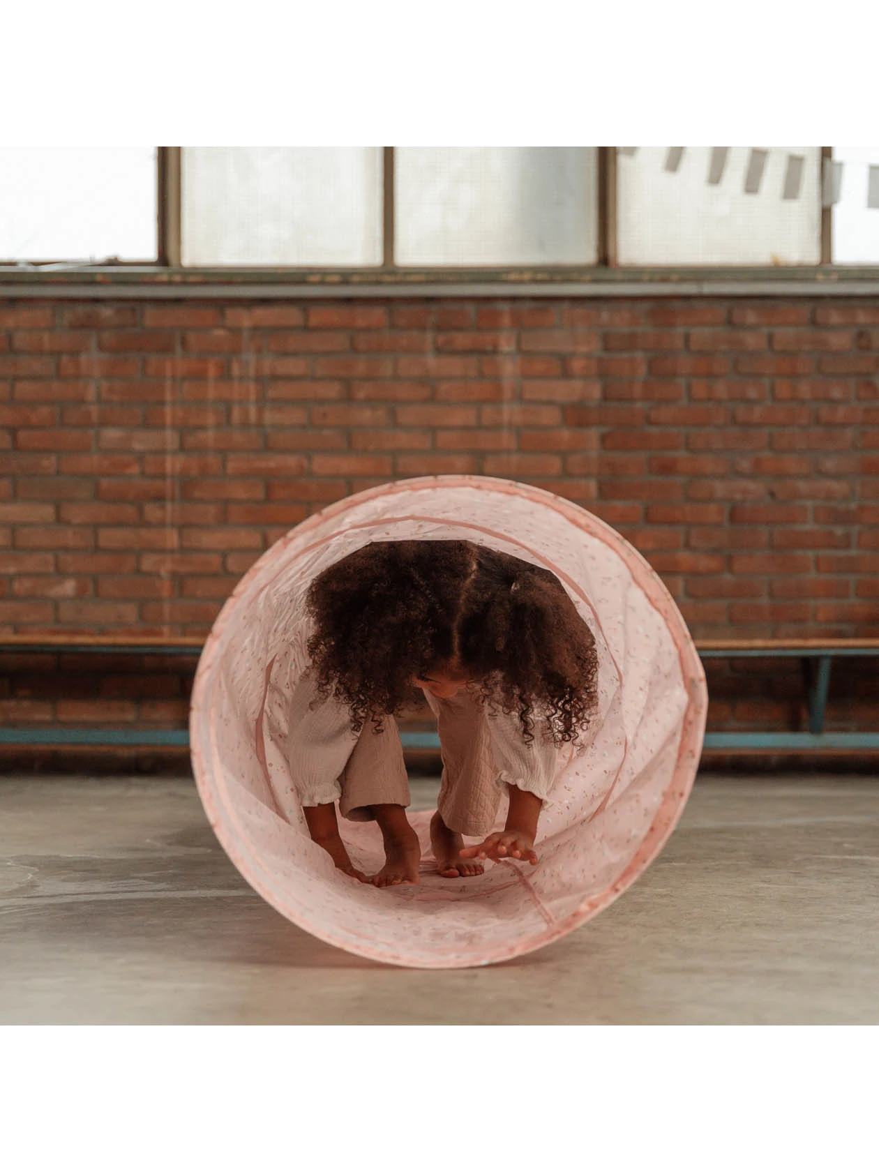 Małe dziecko w środku różowego tunelu marki Little Dutch z serii Pink Flowers.