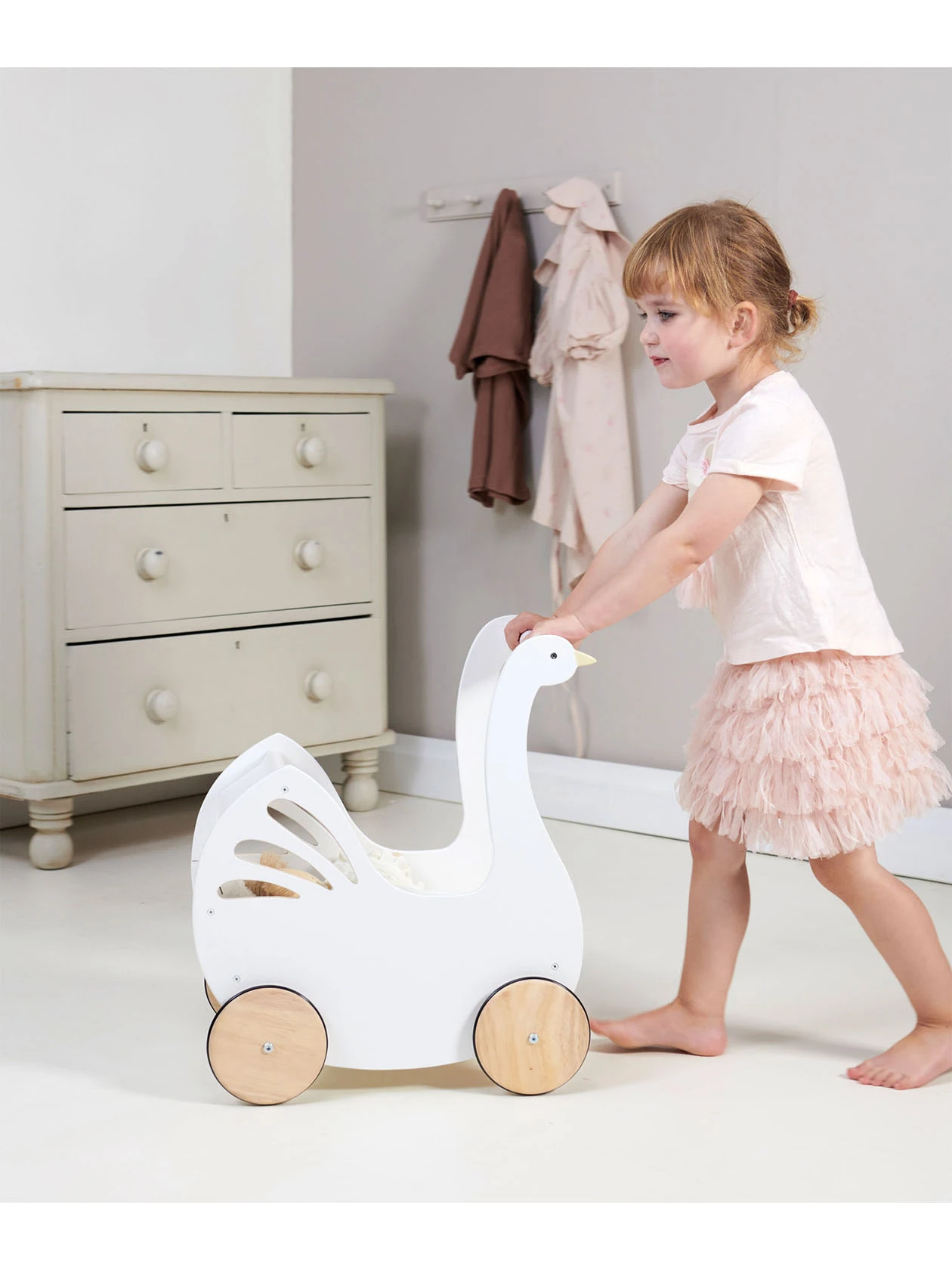 Ma�ła dziewczynka pcha drewniany wózek dla lalek z akcesoriami - Łabędź. Zabawka od Tender Leaf Toys.