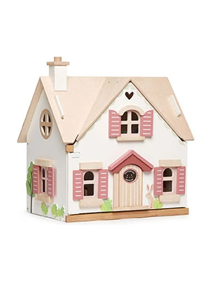 Drewniany domek dla lalek z różowymi okiennicami i różowymi drzwiami.